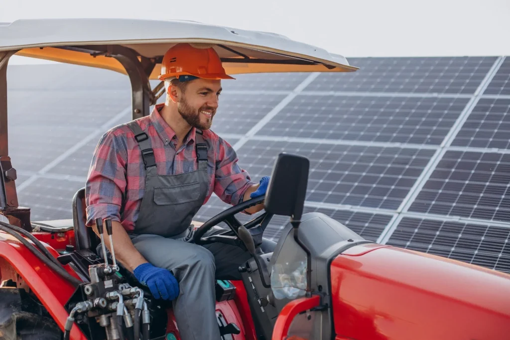 Agriculteur conduisant un tracteur au milieu de panneaux solaires