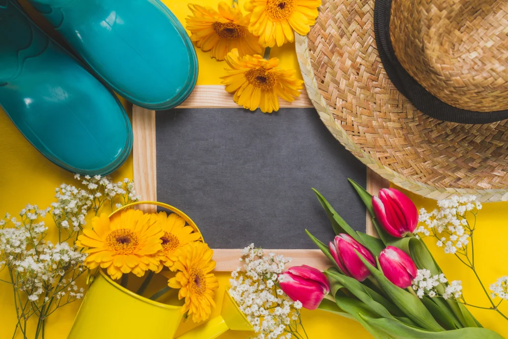 ardoise entourée de fleurs, de bottes et d'un chapeau