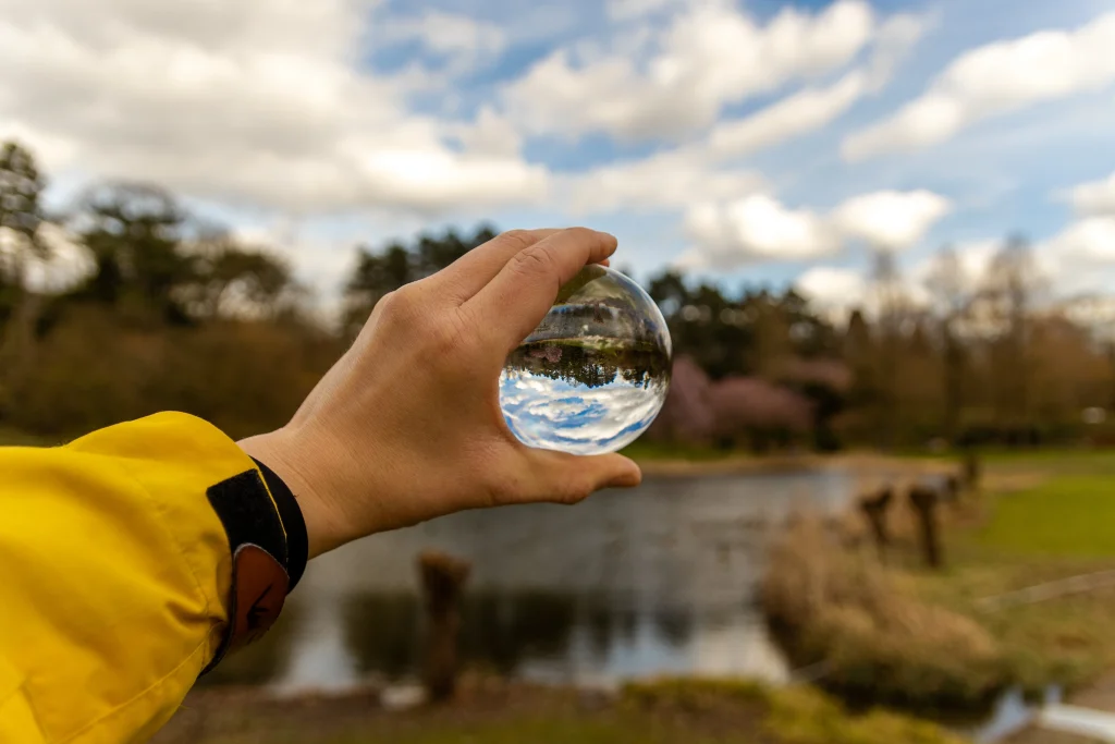 une main avec une goutte d'eau où l'on voit une marre