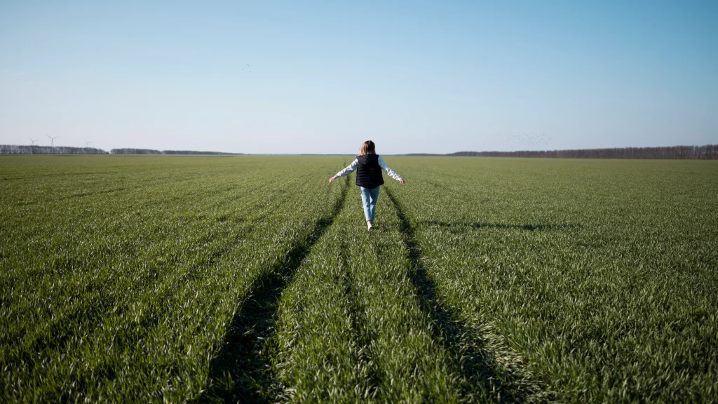 une femme debout dans un champs d'herbe