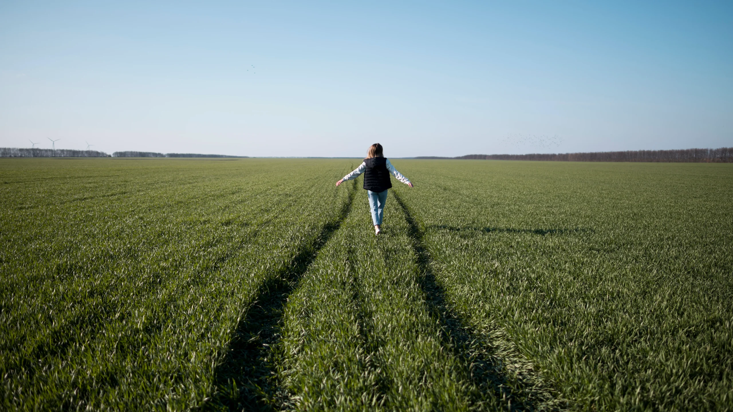 une femme debout dans un champs d'herbe